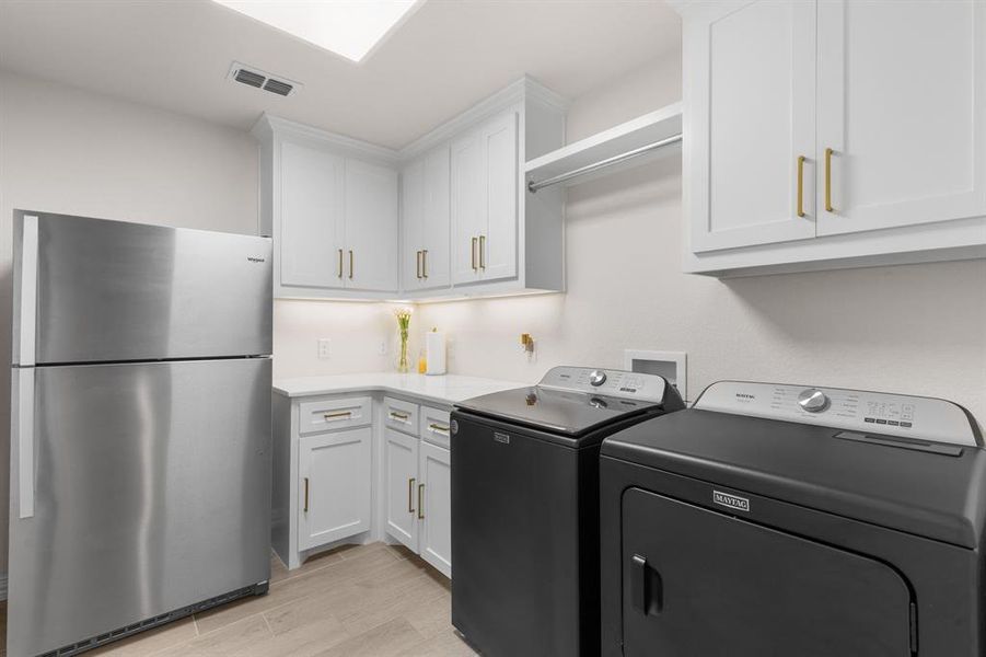 Laundry area with light wood-style floors and washing machine and clothes dryer Laundry area with light wood-style floors and washing machine and clothes dryer