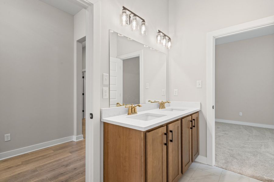 Bathroom with double vanity and baseboards