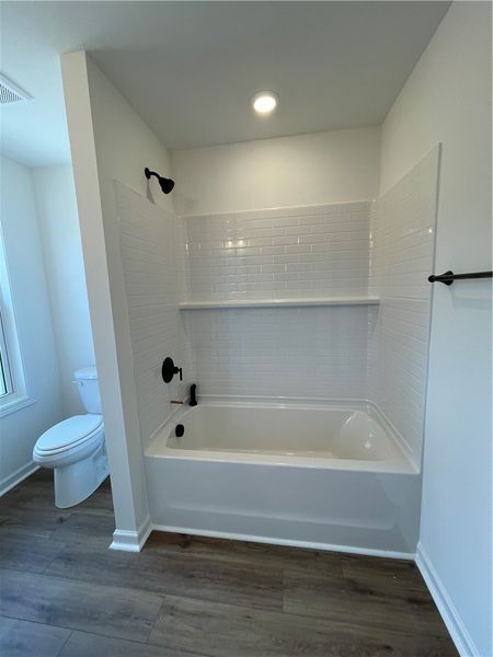 This bright bathroom features a combined shower an