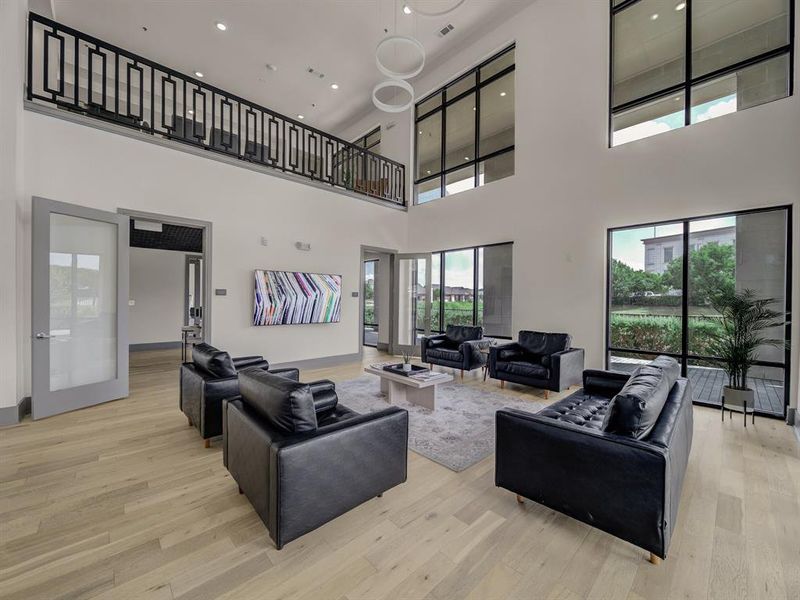 Living room with light wood-type flooring, plenty of natural light, recessed lighting, and a high ceiling Living room with light wood-type flooring, plenty of natural light, recessed lighting, and a high ceiling