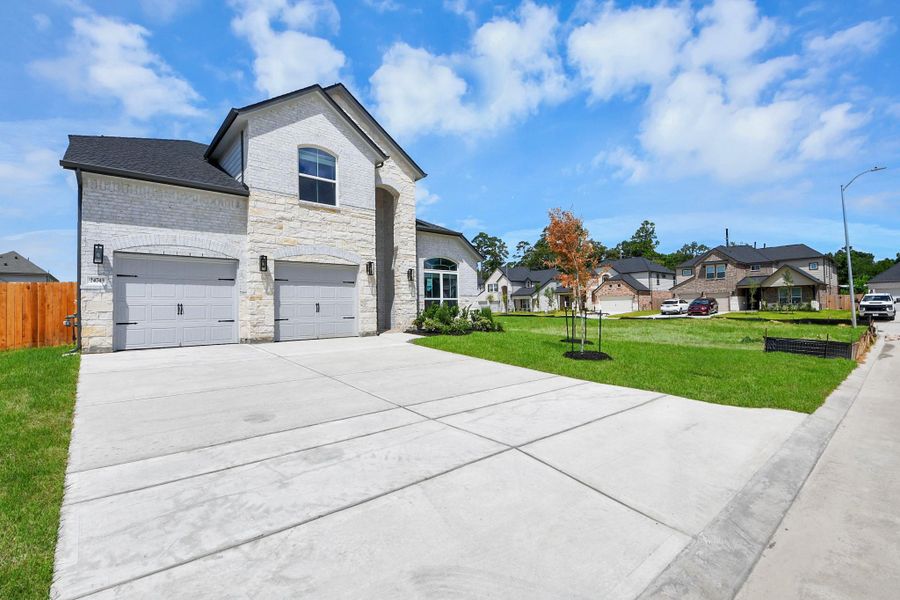 The residence features a practical 2-car garage complemented by a generous driveway, ensuring abundant space for parking needs.