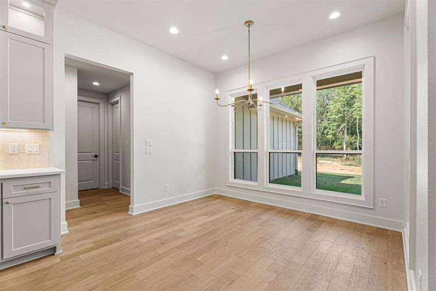 Unfurnished dining area featuring recessed lighting, light wood-style flooring, and a chandelier