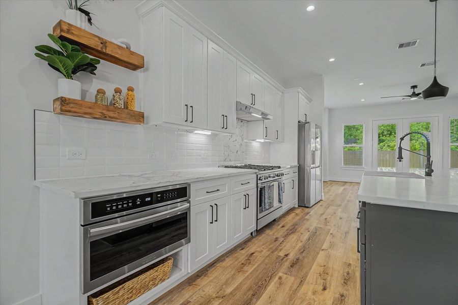 Features a 36-inch Frigidaire Gallery dual-fuel range with air fry and a 30-inch built in microwave oven with drop down drawer.