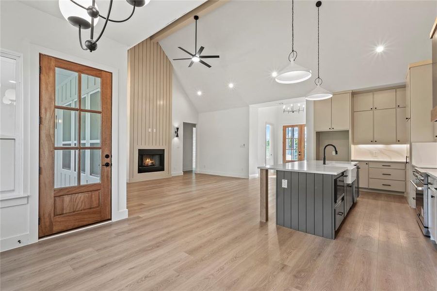 Kitchen with a chandelier, hanging light fixtures, a center island with sink, cream cabinetry, and a kitchen breakfast bar Kitchen with a chandelier, hanging light fixtures, a center island with sink, cream cabinetry, and a kitchen breakfast bar