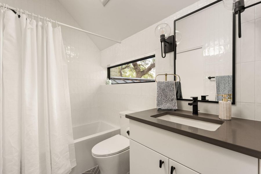 A sleek vanity with a rectangular basin anchors this well-appointed bathroom, featuring modern fixtures and a large mirror. A sleek vanity with a rectangular basin anchors this well-appointed bathroom, featuring modern fixtures and a large mirror.