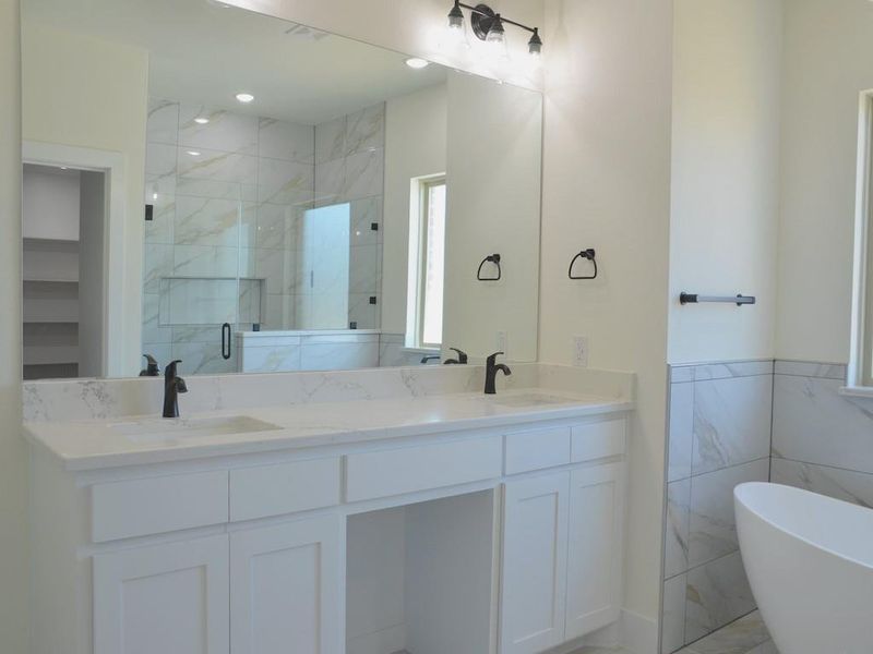 Bathroom featuring vanity, tile walls, and independent shower and bath