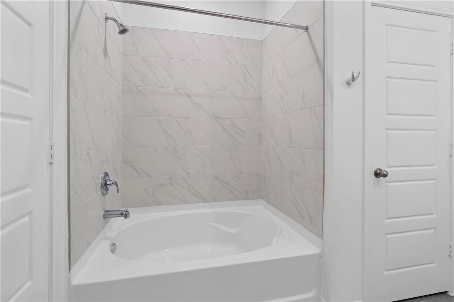 Additional view of the oversized tub and shower combination with tile surround.