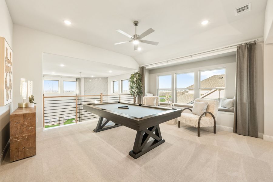 Upstairs game room with pool table, vaulted ceiling, ceiling fan, and open loft railing overlooking lower level