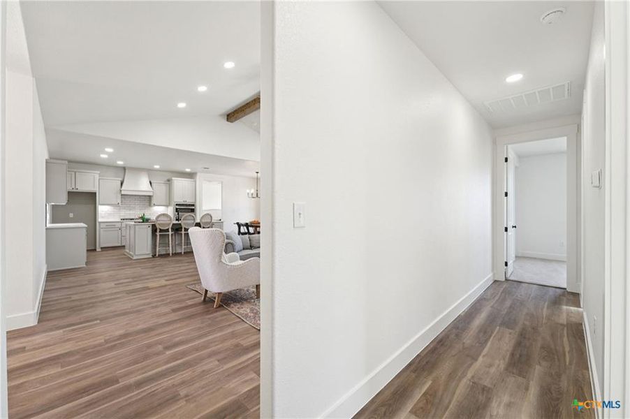 An inviting open-concept layout connects the kitchen and living space, featuring high ceilings and wood flooring. An inviting open-concept layout connects the kitchen and living space, featuring high ceilings and wood flooring.