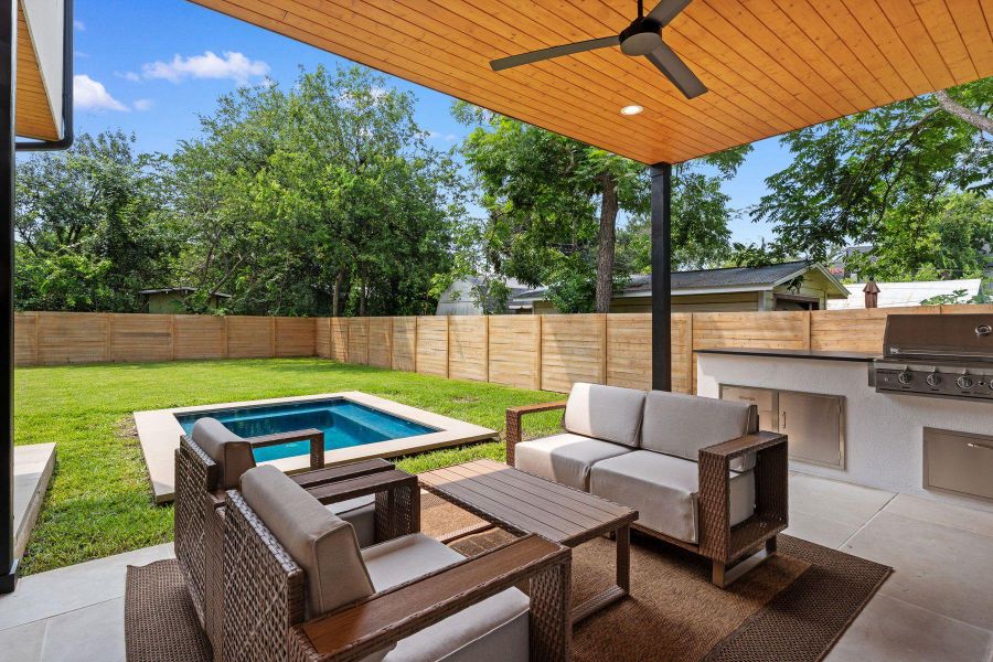 A private outdoor living space with a covered patio, built-in kitchen, and a sparkling pool. A private outdoor living space with a covered patio, built-in kitchen, and a sparkling pool.
