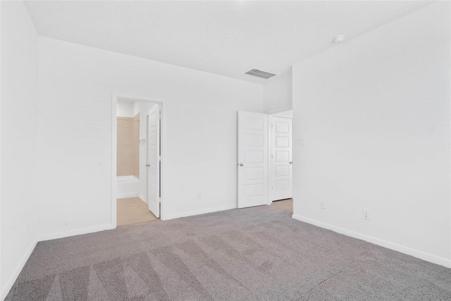 Additional view of the primary bedroom looking towards the primary bathroom.