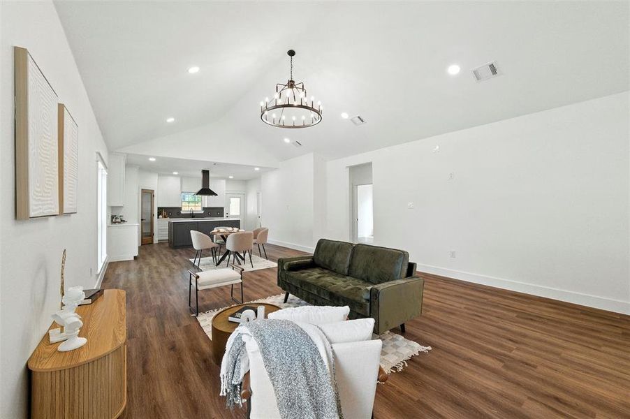Living area featuring a chandelier, wood finished floors, lofted ceiling, and recessed lighting