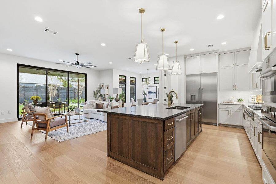 Kitchen with dark stone counters, white cabinets, pendant lighting, stainless steel appliances, and recessed lighting