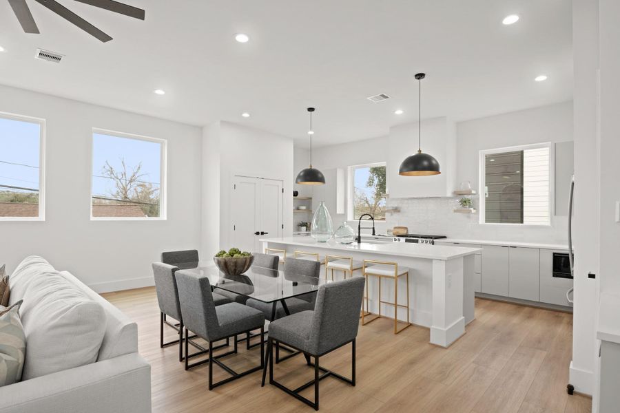 Positioned between the family room and kitchen, the formal dining has recessed lights, large fixed windows adding natural light and gleaming white oak luxury vinyl planked floors.