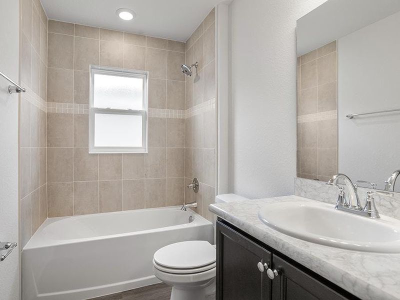 Secondary bedrooms and guests share a convenient hall bath - Remy by Highland Homes Secondary bedrooms and guests share a convenient hall bath - Remy by Highland Homes