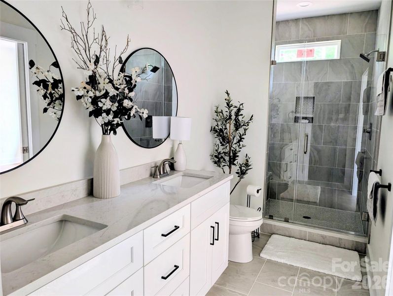 Ensuite bath glass-enclosed shower and exterior window. Ensuite bath glass-enclosed shower and exterior window.