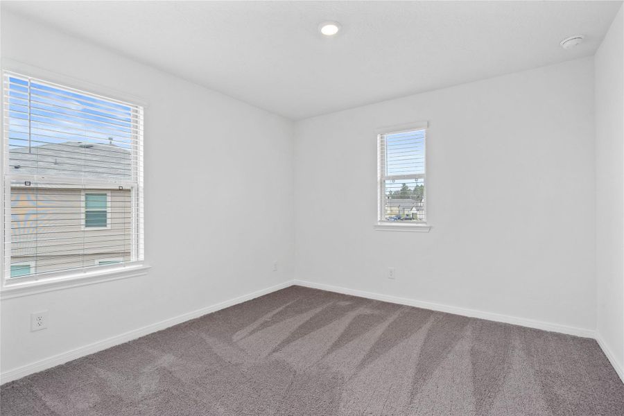 This secondary bedroom offers comfort and style with plush carpeting, neutral paint tones, recessed lighting, windows with blinds, and a generously sized closet. This secondary bedroom offers comfort and style with plush carpeting, neutral paint tones, recessed lighting, windows with blinds, and a generously sized closet.