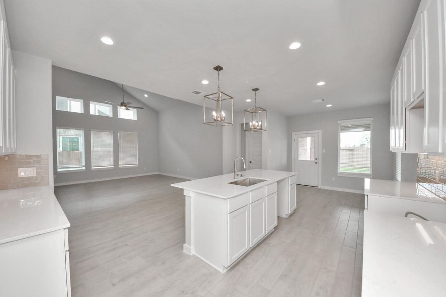 The kitchen is a culinary haven, featuring granite countertops, a tile backsplash, stainless steel appliances, 42” upper cabinets, and undercabinet lighting. Sample photo of completed home with similar floor plan. Actual colors and selections may vary.