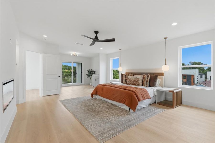 Spacious room featuring light wood-finish flooring, recessed lighting, and a modern ceiling fan Spacious room featuring light wood-finish flooring, recessed lighting, and a modern ceiling fan