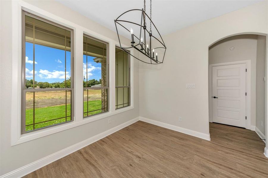 Empty room featuring hardwood / wood-style flooring and a chandelier