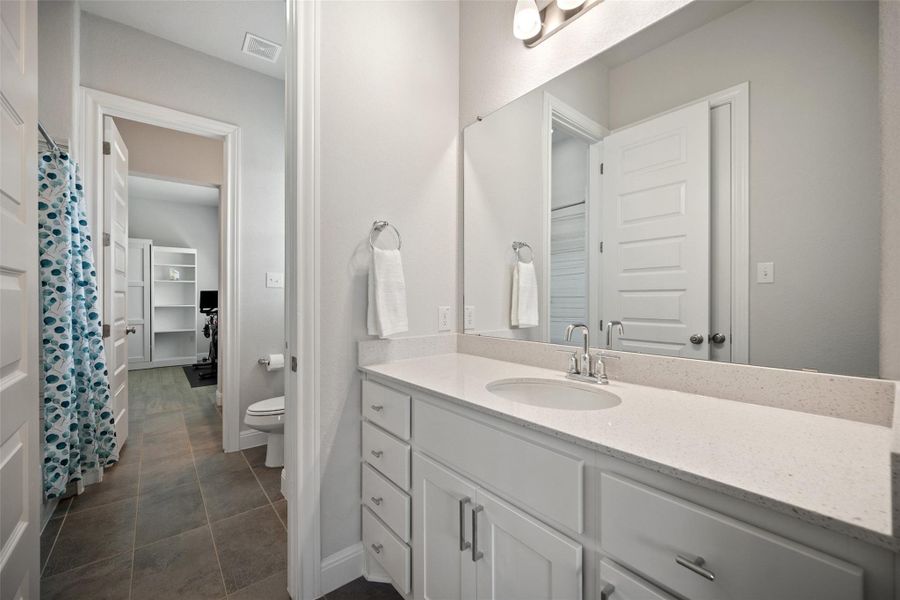 Full bath featuring vanity and curtained shower