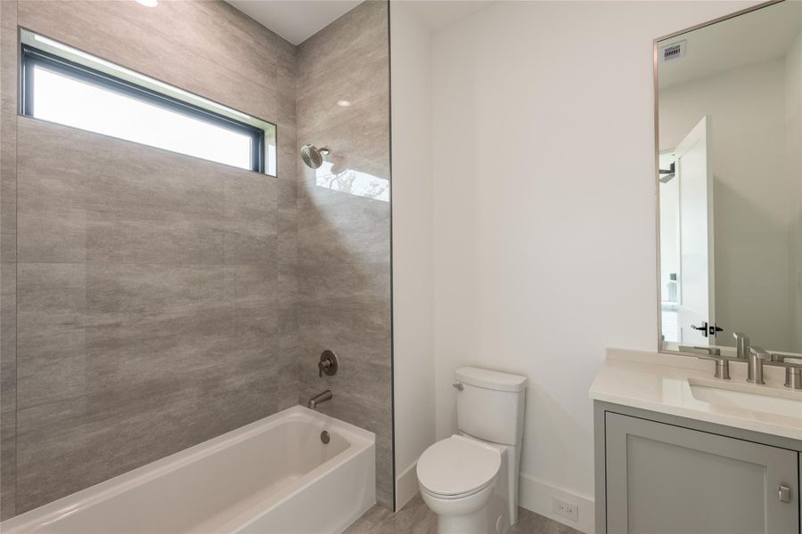 A spacious secondary bathroom featuring a tub and shower