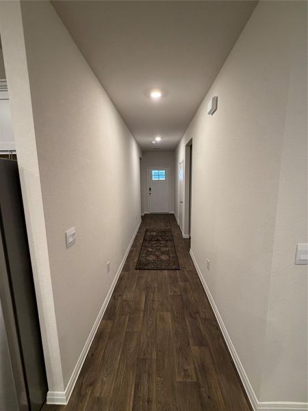 Corridor with baseboards and dark wood-type flooring