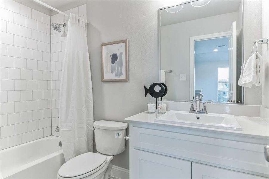 Full bathroom featuring vanity, shower / bath combo, and toilet