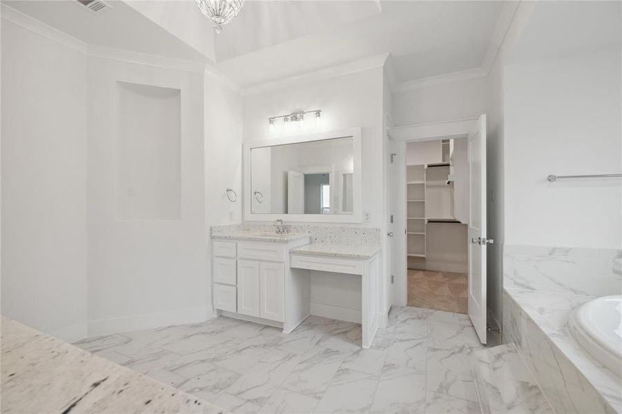 Bathroom featuring vanity, tiled tub, tile patterned flooring, and ornamental molding