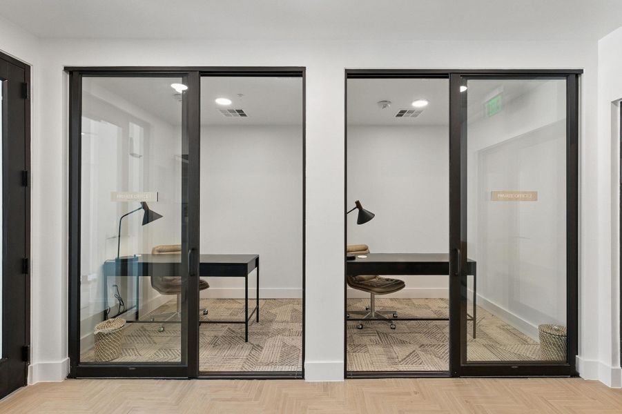 Streamlined private offices, perfect for focused work, featuring sleek glass walls and patterned carpet.