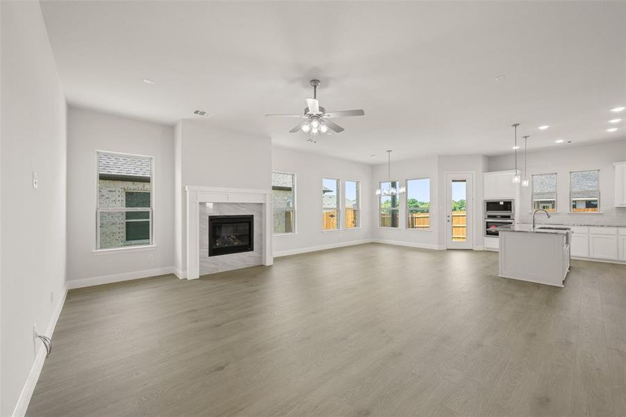 Unfurnished living room featuring recessed lighting, ceiling fan, a high end fireplace, and light wood-style floors Unfurnished living room featuring recessed lighting, ceiling fan, a high end fireplace, and light wood-style floors