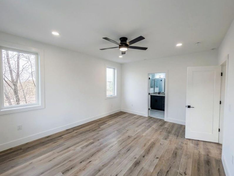 Unfurnished bedroom with light wood finished floors, a ceiling fan, recessed lighting, and ensuite bath