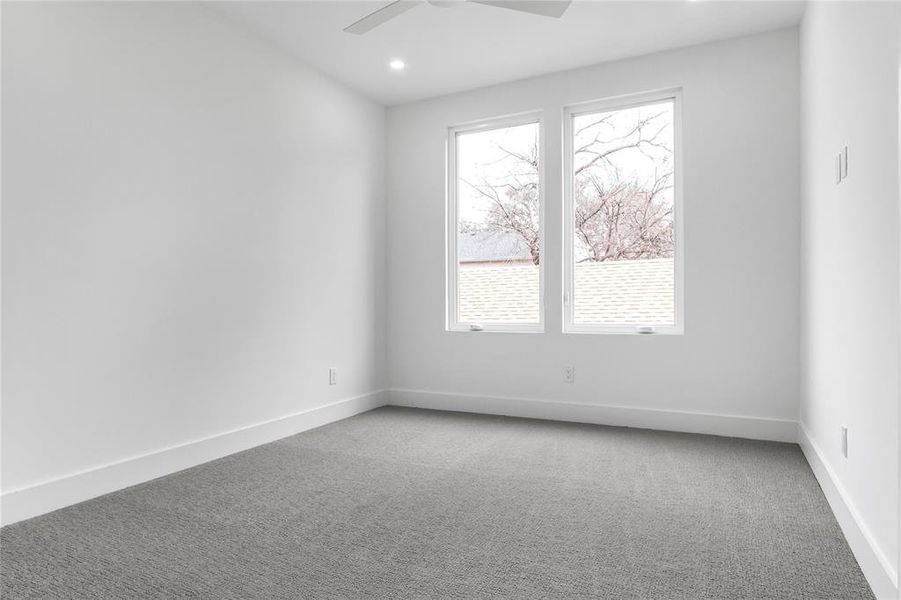 Carpeted spare room with ceiling fan