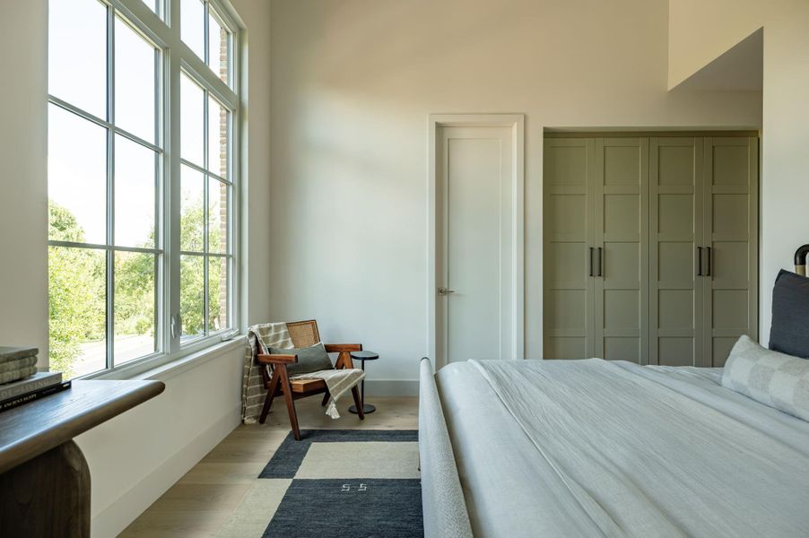 Massive multi-pane windows and soaring ceilings fill this modern bedroom with natural light. Massive multi-pane windows and soaring ceilings fill this modern bedroom with natural light.
