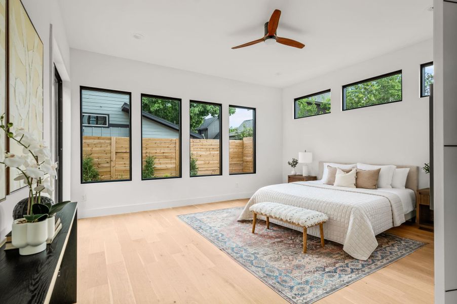 A tranquil bedroom showcases light wood flooring and multiple windows, inviting natural light. A tranquil bedroom showcases light wood flooring and multiple windows, inviting natural light.