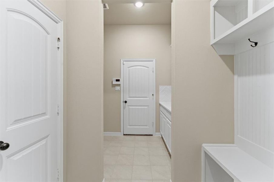 Laundry area with baseboards and light tile patterned floors Laundry area with baseboards and light tile patterned floors