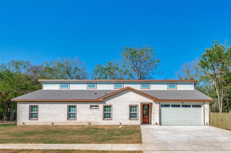 Front of property featuring a front lawn and a garage