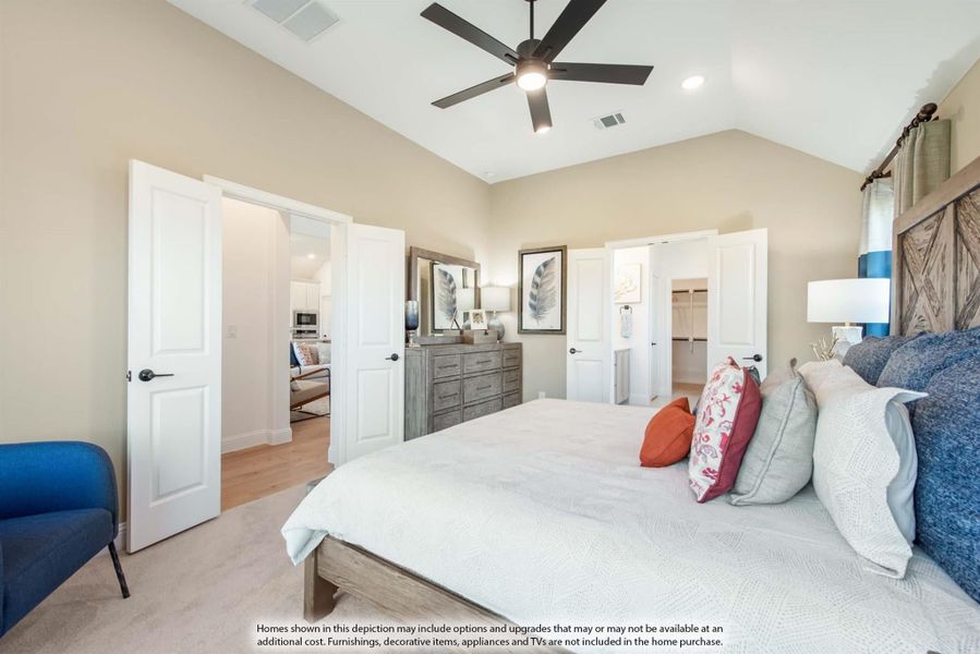 Master bedroom with vaulted ceiling, ceiling fan, barn door headboard, and walk-in closet entrance visible