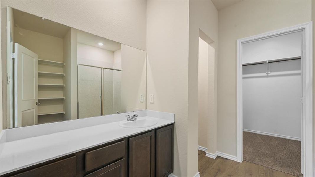 Bathroom vanity with a white countertop and dark wood-finish cabinetry