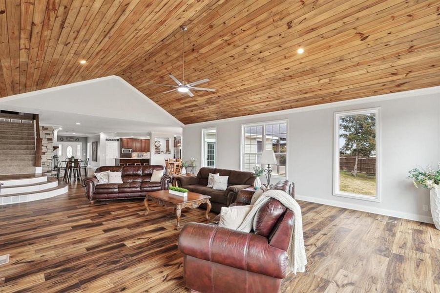 Living room with wood ceiling, ceiling fan, vaulted ceiling, and hardwood / wood-style flooring