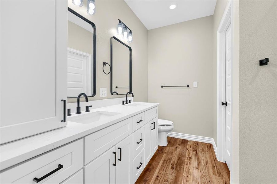 Bathroom with hardwood / wood-style floors, vanity, and toilet