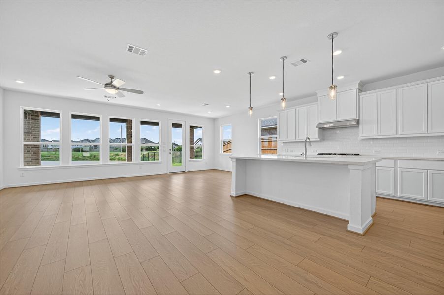 The spacious kitchen island features sleek countertops, perfect for meal prep, casual dining, and gathering with friends and family