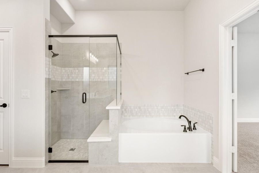 Master bathroom with glass-enclosed tile shower and soaking tub with dark bronze fixtures Master bathroom with glass-enclosed tile shower and soaking tub with dark bronze fixtures