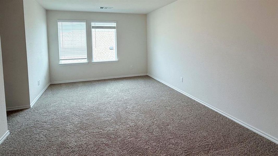 Carpeted spare room featuring baseboards Carpeted spare room featuring baseboards