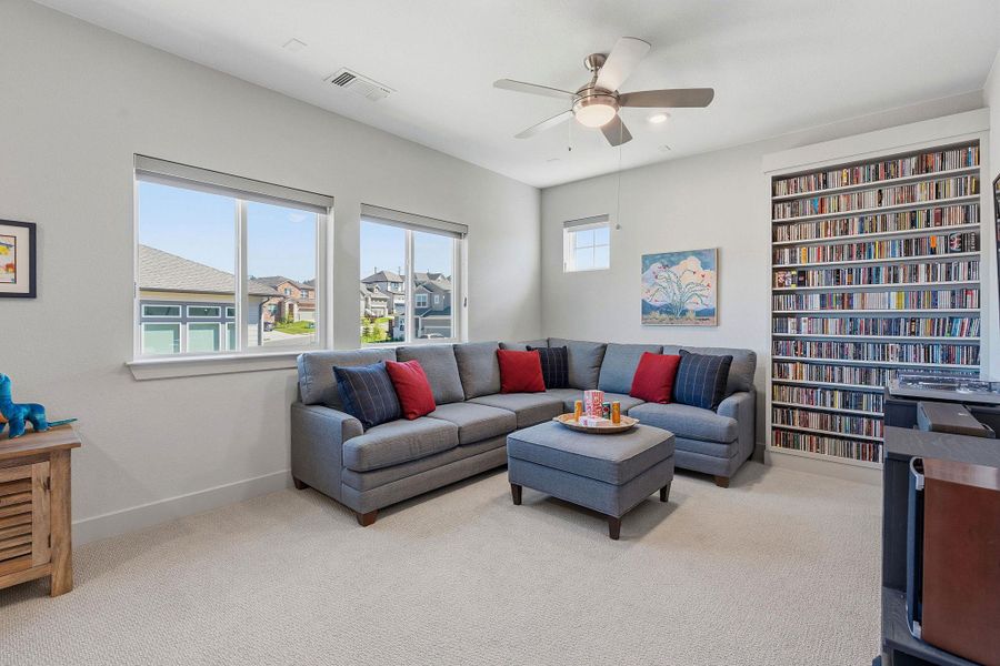 Living area with a ceiling fan and light colored carpet Living area with a ceiling fan and light colored carpet