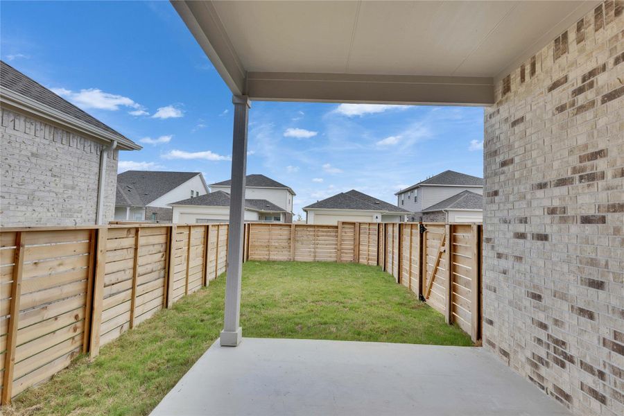Fenced backyard with a patio area and a residential view