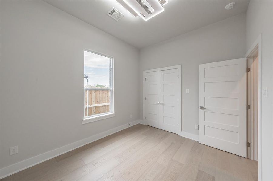 Unfurnished bedroom with light wood finished floors and a closet