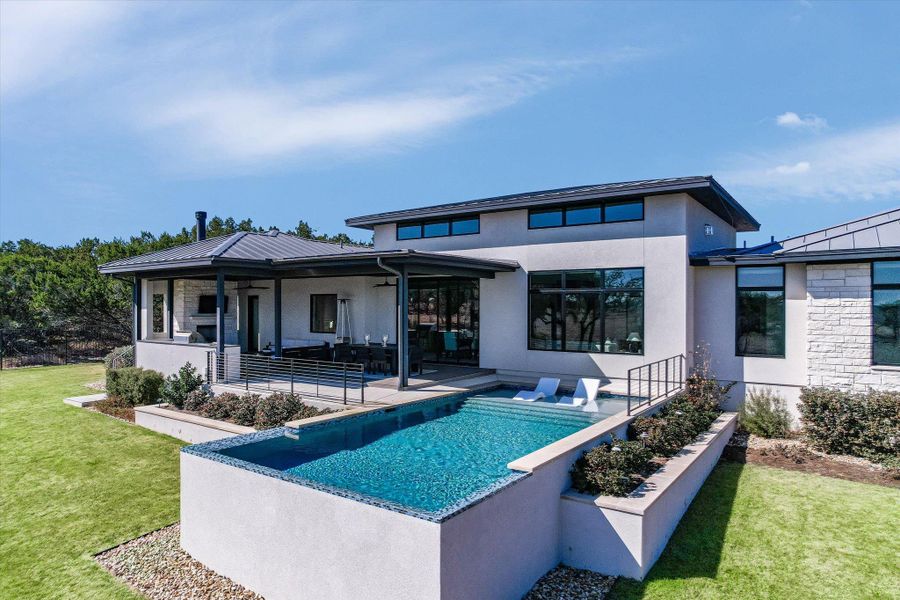 Rear view of house with a yard, a patio area, an outdoor pool, and stucco siding Rear view of house with a yard, a patio area, an outdoor pool, and stucco siding