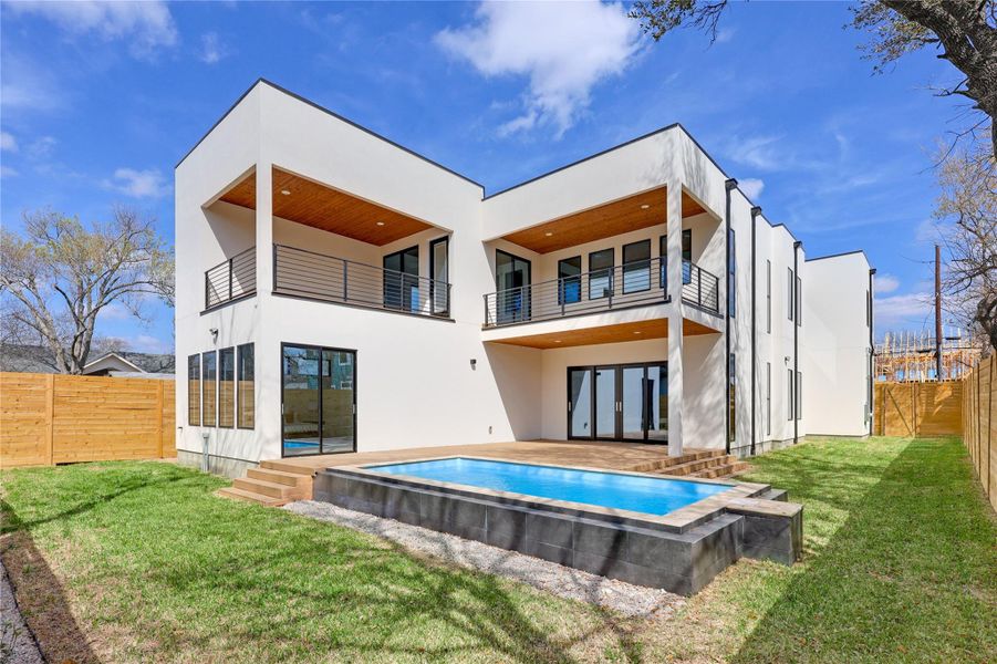 Back of house featuring a fenced backyard, stucco siding, and a patio