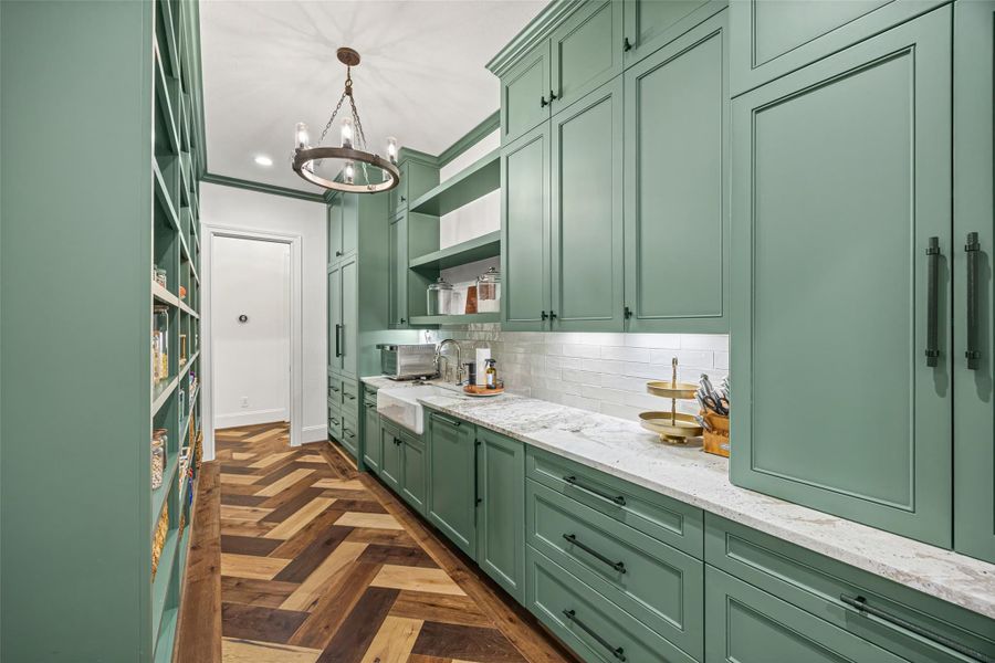 Expansive behind-the-kitchen walk-through pantry with seamless flow, a dedicated prep sink, and panel-ready fridge, dishwasher, and ice maker. Expansive behind-the-kitchen walk-through pantry with seamless flow, a dedicated prep sink, and panel-ready fridge, dishwasher, and ice maker.
